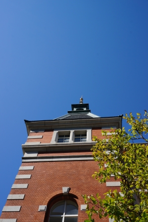 Blue autumn sky, yellow leaves and red bricks