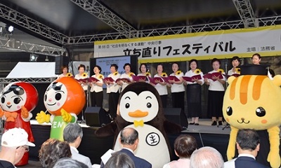 「咲き誇る花のように」(作詞・作曲:谷村新司)の合唱(法務省のマスコットキャラクターたちも応援(左から人KENあゆみちゃん・人KENまもる君・更生ペンギンのホゴちゃん・ホウリス君)