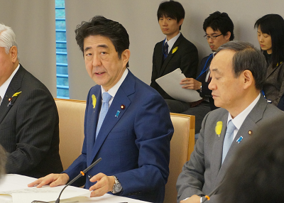 幸福の黄色い羽根を着用する安倍首相