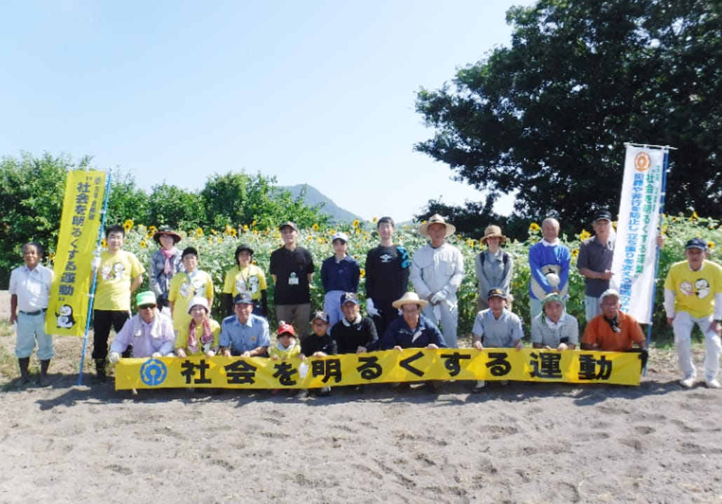 社会を明るくする運動の横断幕を持つ運動の参加者数十名による集合写真。